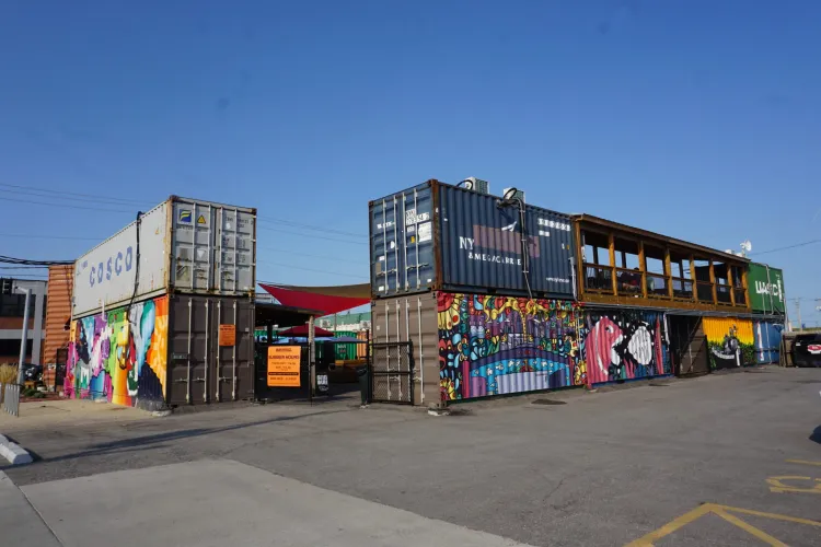 The Iron District is an outdoor food and retail park in North Kansas City built using colorful shipping containers, featuring local food spots, small boutique shops, and a central area with picnic tables